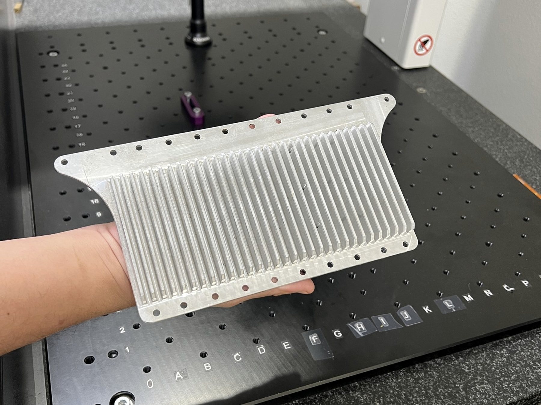 Machined part on the granite plate beneath a measuring probe