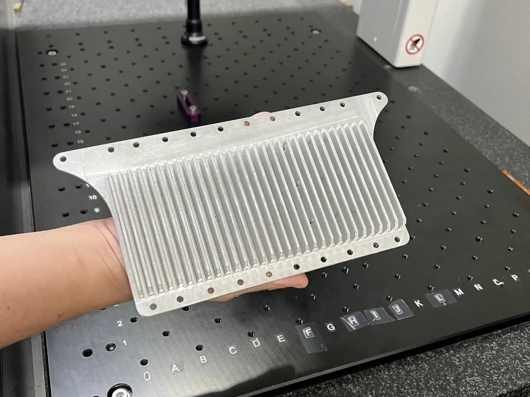 Machined part on the granite plate beneath a measuring probe
