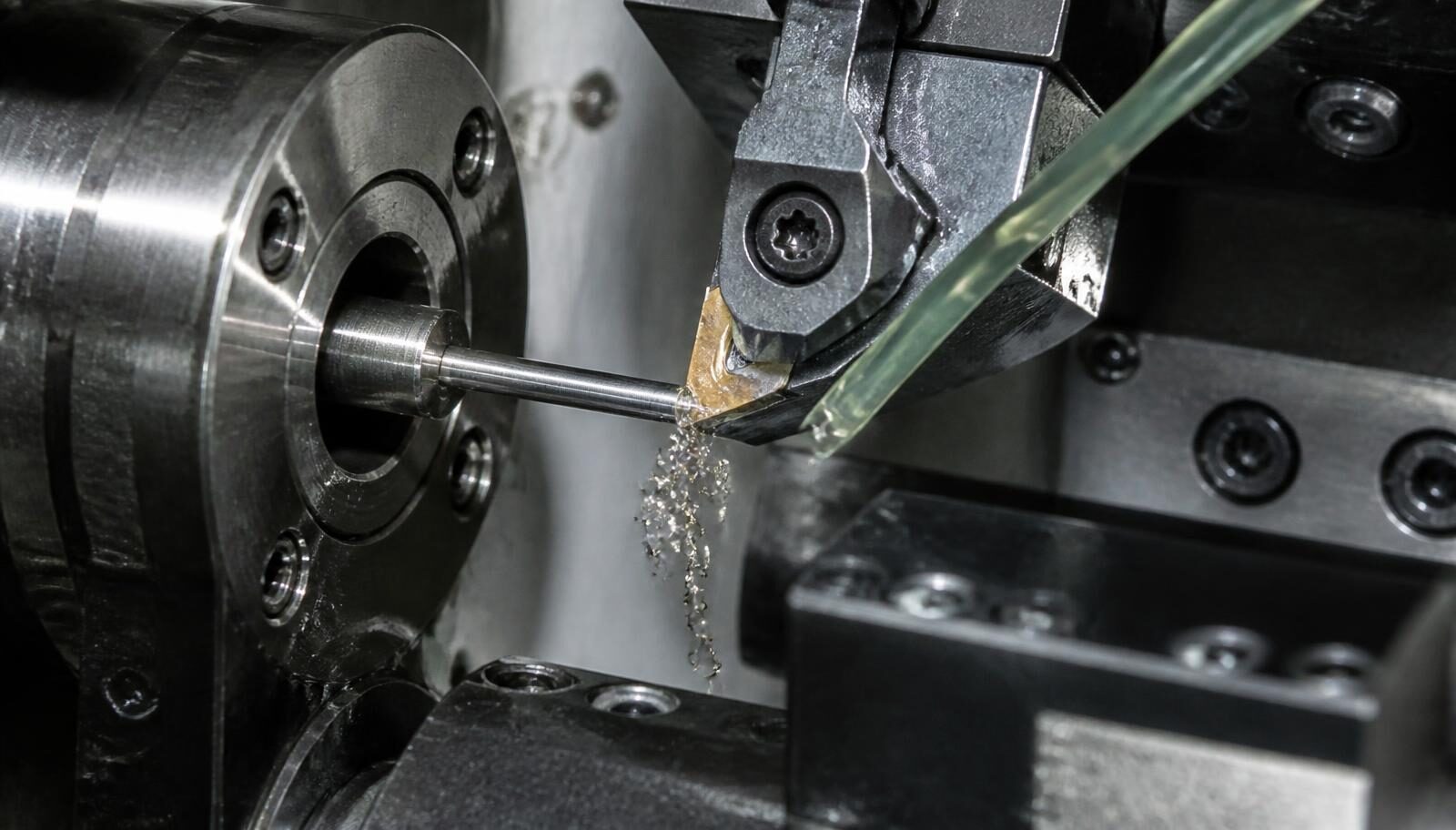Close-up of a slim stainless bar being turned near the guide bushing inside a Swiss-type CNC lathe